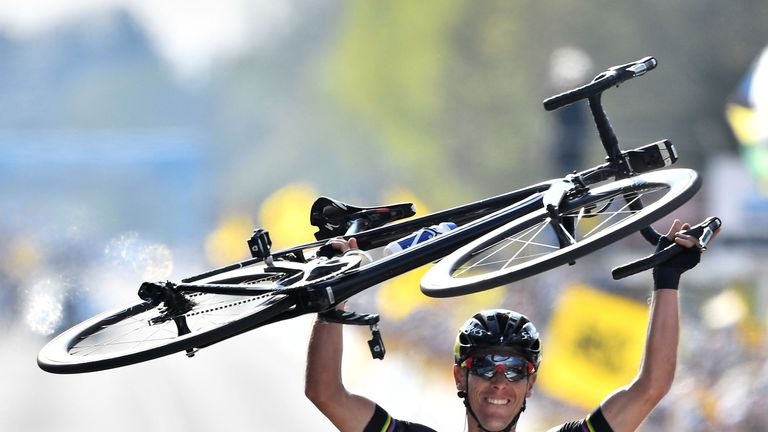 Philippe Gilbert lifts his bike aloft as he wins the Tour of Flanders