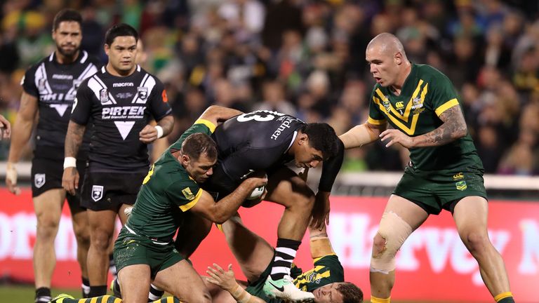 Jason Taumalolo is tackled by Australia's Cameron Smith (left), Trent Merrin and David Klemmer (right)
