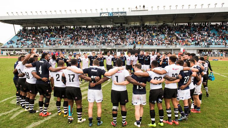 The Fiji and Scotland players huddle at full-time