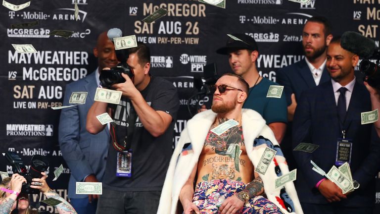 McGregor looks on as money rains down during the Floyd Mayweather Jr v Conor McGregor World Press Tour