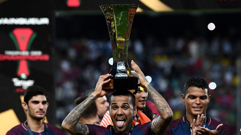 Alves holds aloft the trophy