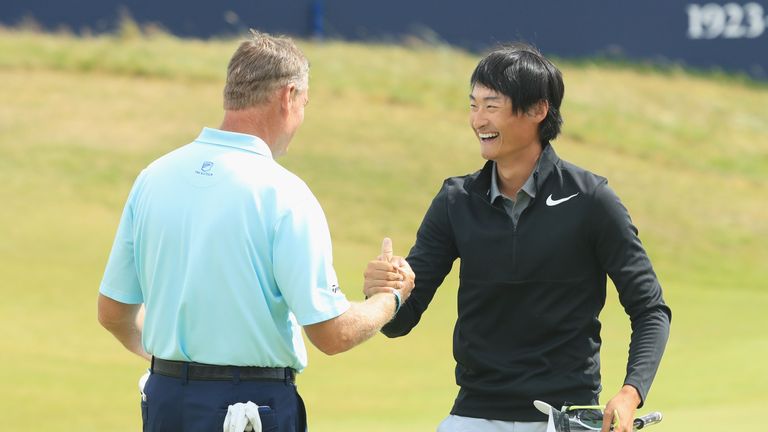 Haotong Li is congratulated by Ernie Els after completing his round of 63