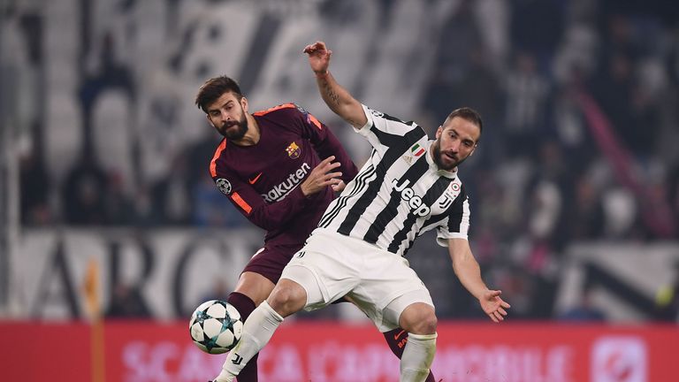 Barcelona defender Gerard Pique battles for the ball with Juventus' Gonzalo Higuain