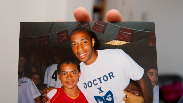 Brentford midfielder Nico Yennaris holds a photo of himself with Arsenal legend Thierry Henry