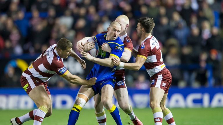 Warrington's Mitch Brown is tackled by Wigan's Tony Clubb, Liam Farrell and Oliver Gildart