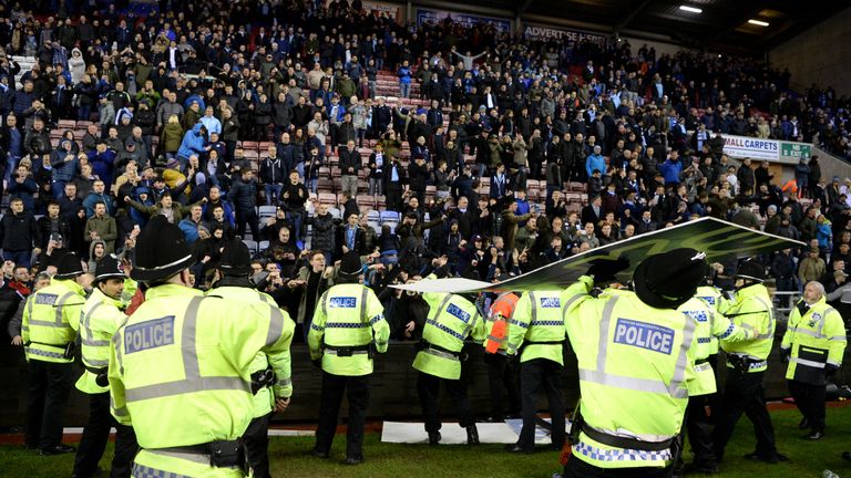 An advertising board was thrown at police as they attempted to prevent a pitch invasion