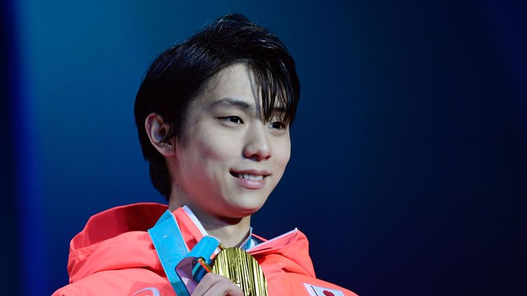 Hanyu poses on the podium during the medal ceremony