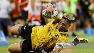 Alex Fidow of Hurricanes is tackled by Sebastian Cancelliere of Jaguares