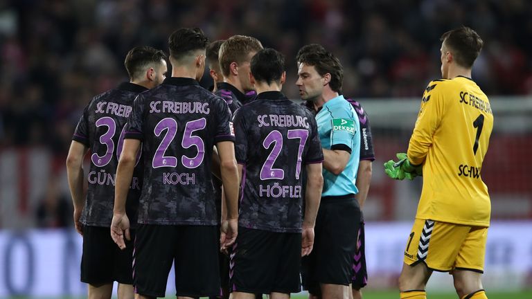 Freiburg player surround referee Guido Winkmann