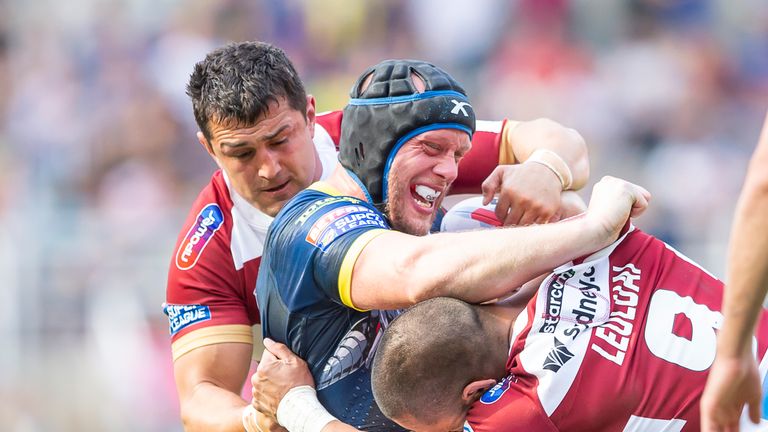 Warrington's Chris Hill is tackled by Wigan's Ben Flower and Thomas Leuluai