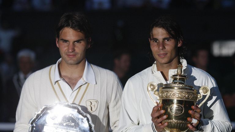 The players pose in near darkness with their trophies after the match