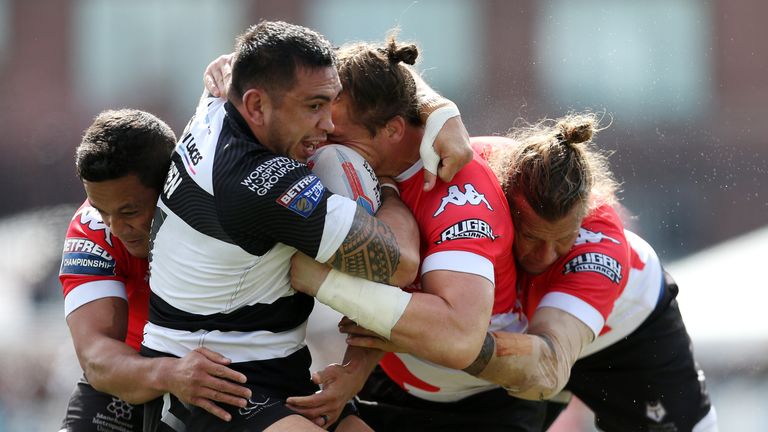 Harrison Hansen of Widnes Vikings is tackled by Chase Stanley, Andrew Dixon and Ashton Sims of Toronto Wolfpack.