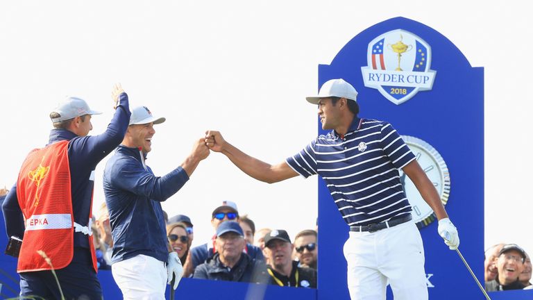 Tony Finau celebrates with Brooks Koepka after his fortuitous tee shot at 16