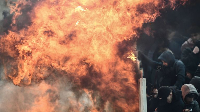 Social media video shows home fans throwing a petrol bomb at visiting Ajax supporters during clashes at the Olympic stadium.