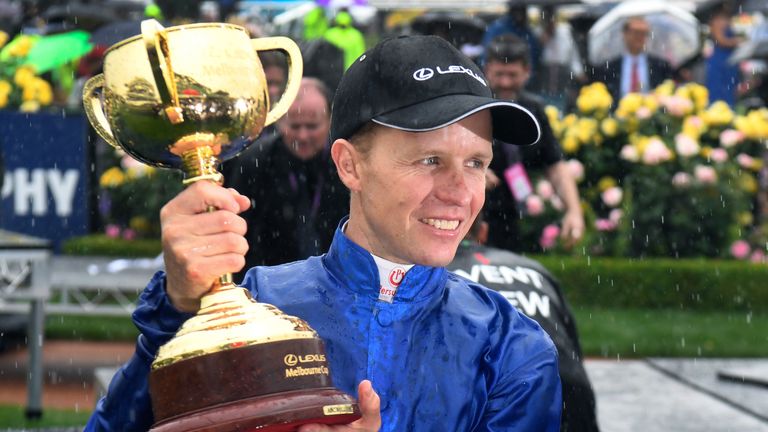 Jockey Kerrin McEvoy holds the Melbourne Cup in the mounting yard after his victory on Cross Counter