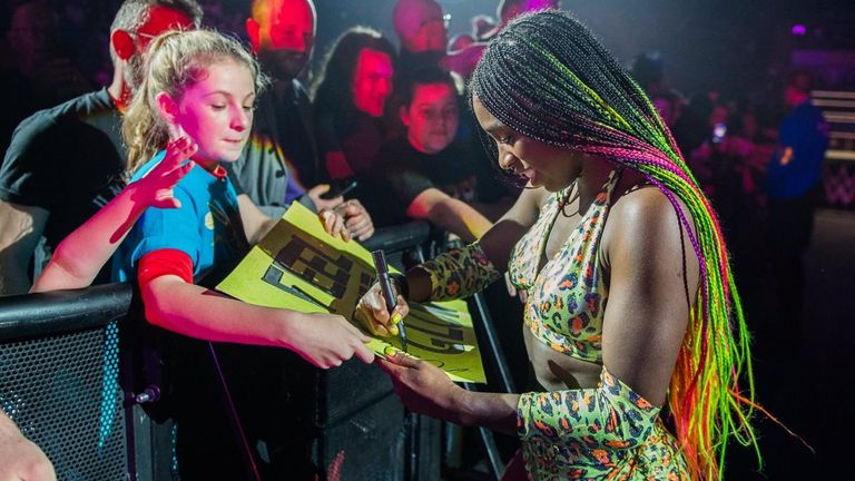 Naomi signs a young fan's poster in support of her at the WWE event in Nottingham