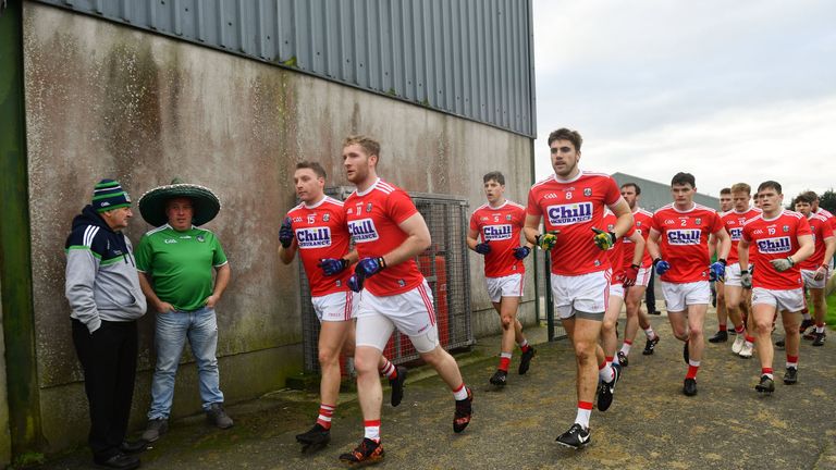 Scouting the opposition: Two Limerick fans watch as the Cork footballers emerge for the McGrath Cup semi-final