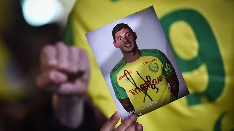 A member of the public holds up a photograph of Sala during a vigil in Nantes