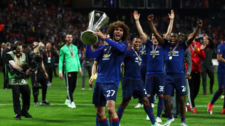 Fellaini holds the trophy of the Europa League