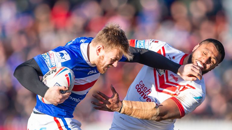 Wakefield's Tom Johnstone fends off St Helens' Dominique Peyroux