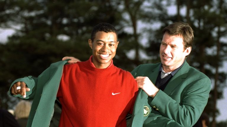 Nick Faldo helps Woods into his first green jacket in 1997