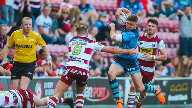 Tommy Makinson is tackled by Wigan's George Williams.