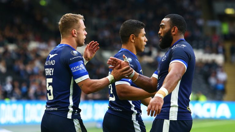 Tierney of Catalans Dragons celebrates with teammates after scoring a try