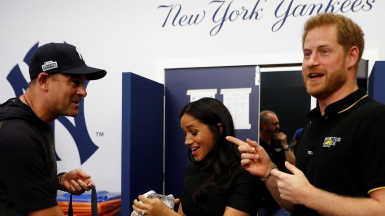 New York Yankees manager Aaron Boone presents the royal couple with a gift for their son Archie