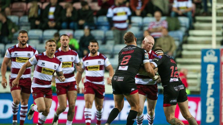 Wigan's Liam Farrell is tackled by Salford's Lee Mossop and George Griffin