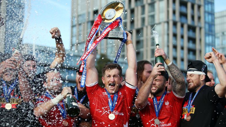 Josh McCrone lifts the trophy as Toronto celebrate their promotion