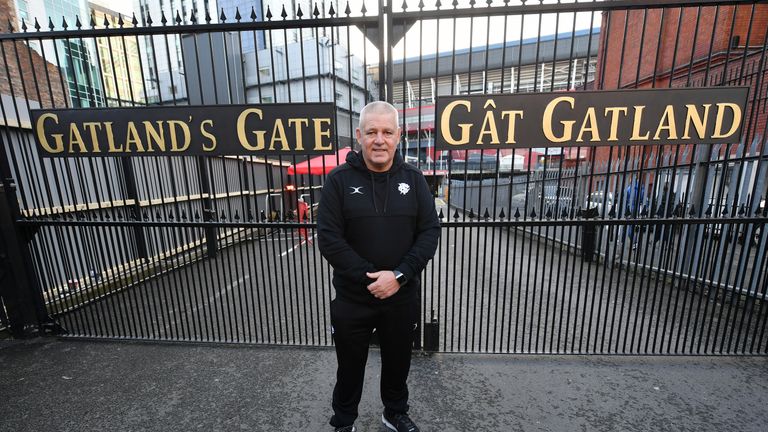 Warren Gatland in front of the gates named after him