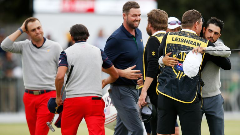 Marc Leishman and Abraham Ancer celebrate after halving their match against Justin Thomas and Rickie Fowler
