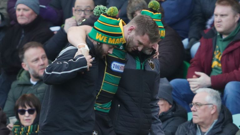 Dan Biggar is helped off the field during Northampton's clash with Saracens