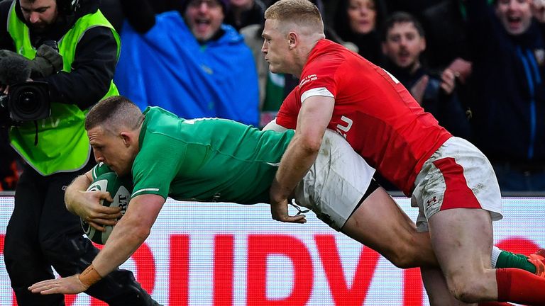 Andrew Conway dives over to score Ireland's bonus-point try despite the efforts of Johnny McNicholl