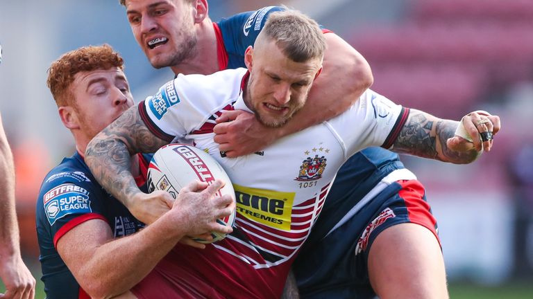 Wigan's Dom Manfredi is tackled by Hull KR's George Lawler and Harvey Livett