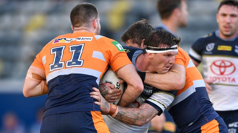 Josh McGuire of the Cowboys is tackled by Lachlan Fitzgibbon and Andrew McCullough of the Knights