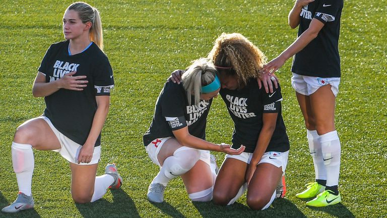 Julie Ertz (centre left) consoles Red Stars teammate Casey Short (centre right) as the pair take a knee during the US national anthem