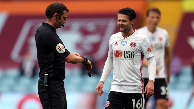 Referee Michael Oliver points to his watch to signal the goal line technology did not give a goal