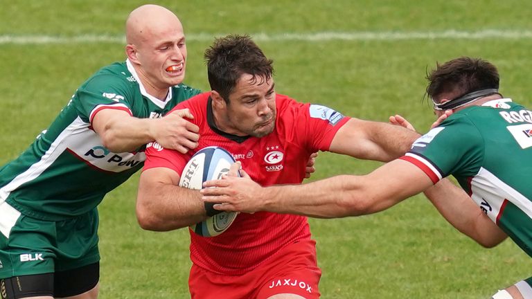 Brad Barritt is tackled by London Irish's Matt Rogerson (R) and Jacob Atkins