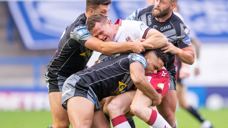 Wigan's Joe Burgess is tackled by Castleford's Alex Foster, Derrel Olpherts and Paul McShane