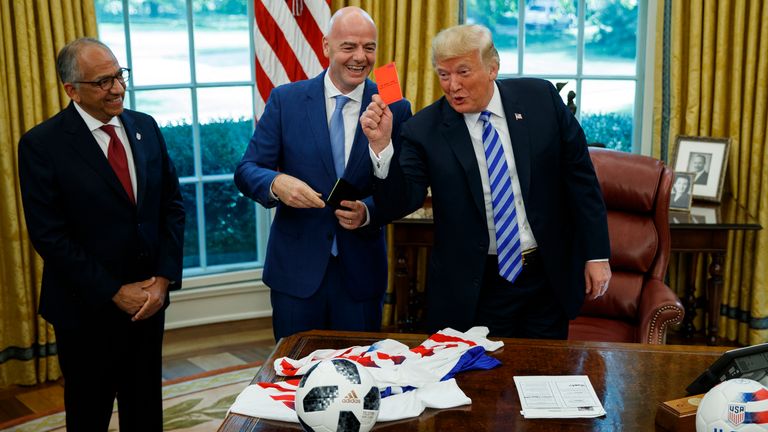 Trump shows the red card to the media in the Oval Office after FIFA President Gianni Infantino explains the use of yellow and red cards in football