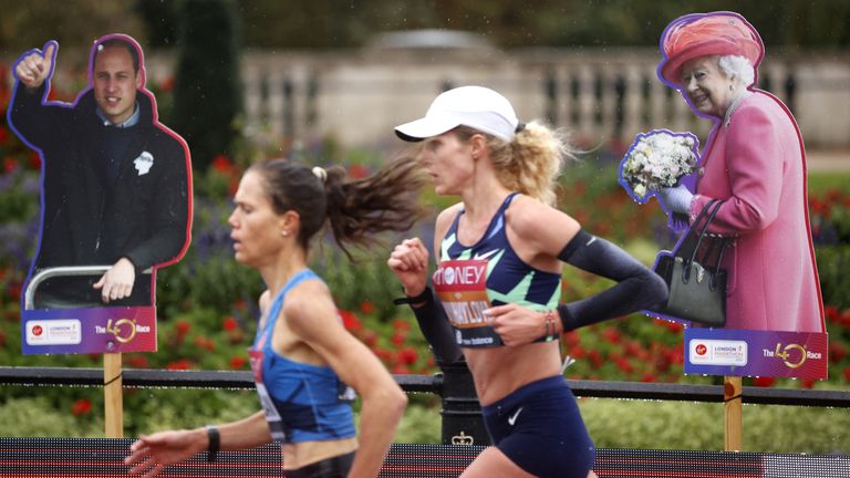 London Marathon competitors make their way past cardboard cutouts of Prince William and the Queen after spectators were forbidden from attending (Pic: PA)