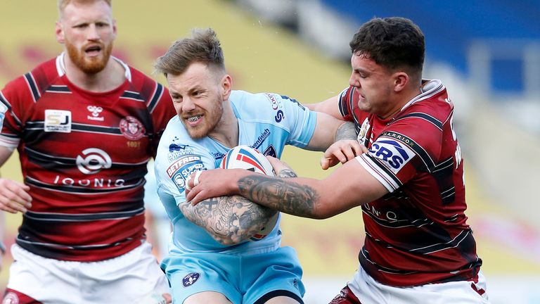 Wakefield Trinity's Tom Johnstone and Wigan Warriors' Oliver Partington in action