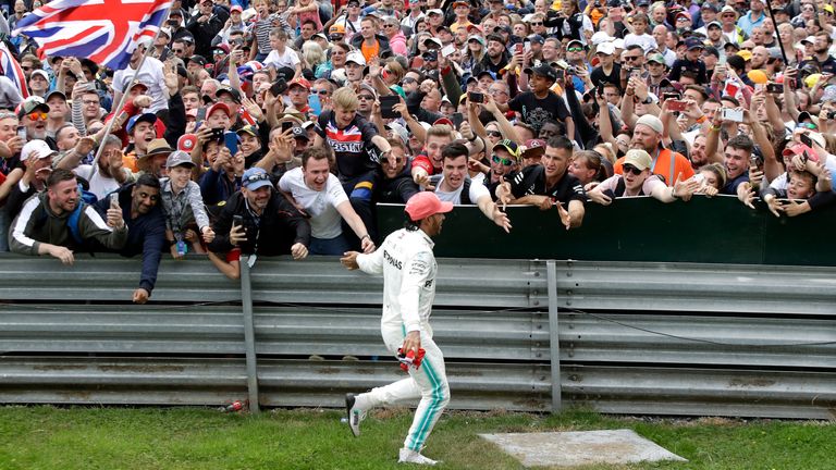 Lewis Hamilton high-fives fans after his British GP win back in 2019