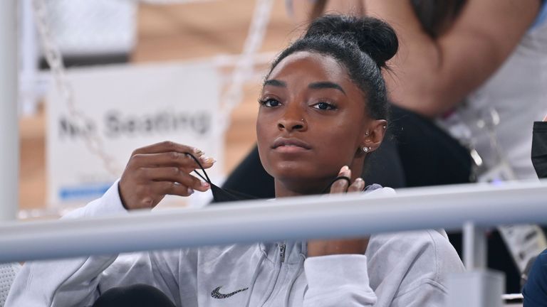 Simone Biles watches her team-mates from the stands after withdrawing from the women's team all-around final