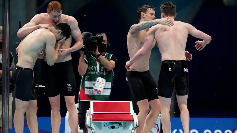 Britain's men's 4x200-meters relay team of Tom Dean, James Guy, Matthew Richards, and Duncan Scott celebrate after winning the gold medal