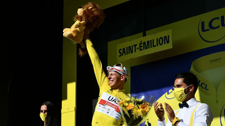 Pogacar del equipo UAE Emirates celebra su maillot amarillo como líder general en el podio al final de la vigésima etapa