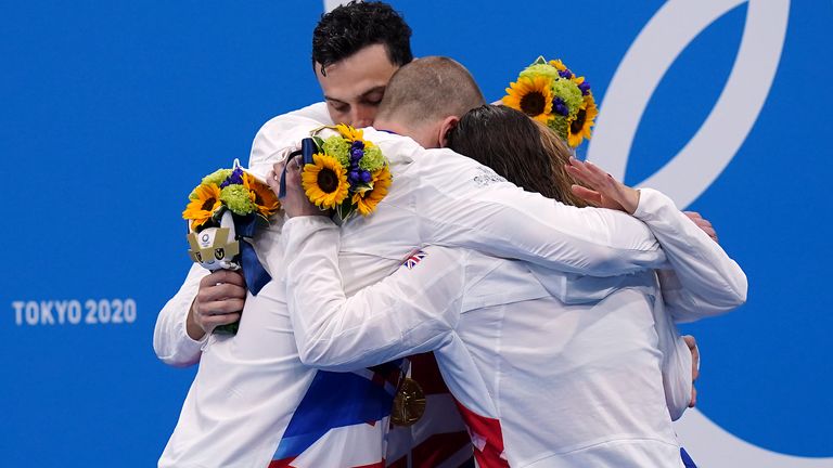The 4x100m mixed medley team embrace eachother after claiming gold