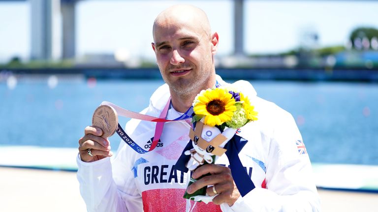 Liam Heath collects his bronze medal on the podium after finishing third in the men's 200m canoe sprint final