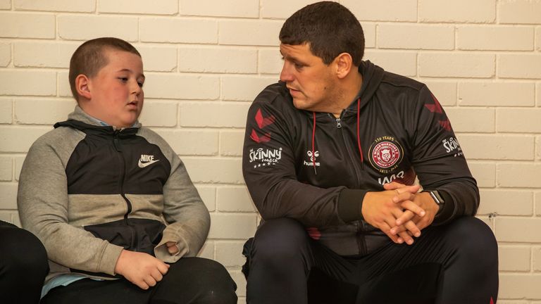 Wigan Warriors head coach Matt Peet speaks to a pupil during the Warriors Unite session at St Benedict's